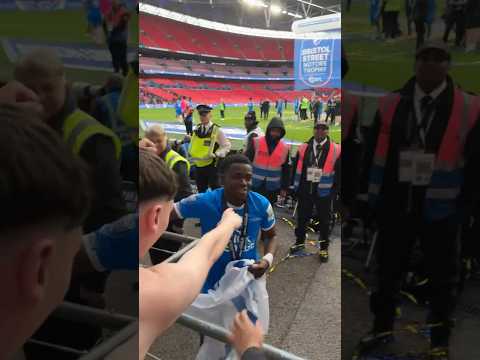 Kwame Poku collects a fans flag after Bristol Street Motors win