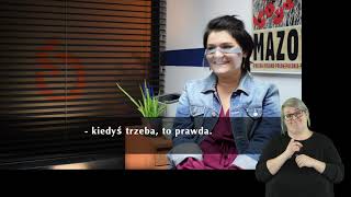 Na pierwszym planie widać uśmiechnięta kobietę o ciemnych włosach, ubraną w kurtkę jeansową. Ma na twarzy przyłbicę. W tle fogo Fundacji Aktywizacja. Na dole, na czarnym pasku znajdują się napisy - transkrypcja wypowiedziW prawym, dolnym rogu widać sylwetkę tłumacza PJM.