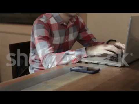 Young man typing on his laptop in cafe