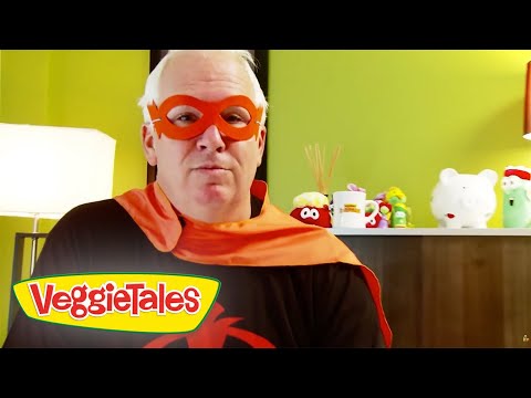 Man wearing a red superhero mask and orange cape in a room with VeggieTales logo foregrounded on the bottom left.