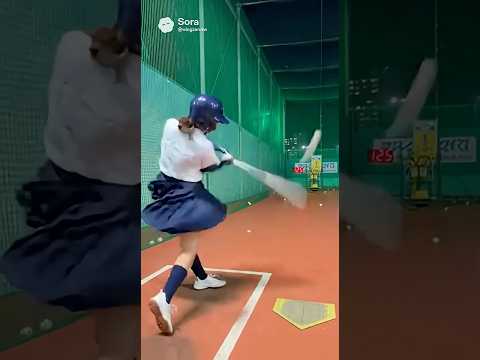日本の女子高生がバッティングセンターで野球を打ち、カキーンと快音を響かせる。