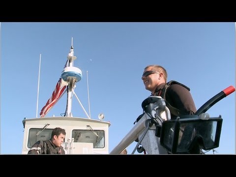 An Air Rescue Swimmer Jumps out of a Helicopter