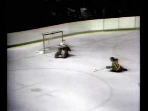 Bobby Clarke scores a goal sliding on the ice