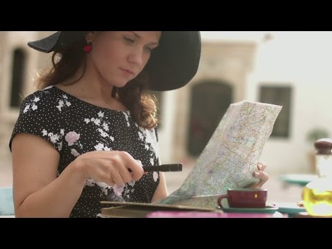 Beautiful woman in anticipation of summer vacation planning trip abroad with map. Stock Footage