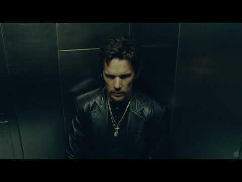 Trailer close-up: tense stare before a raid as score simmers