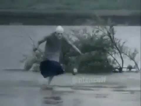 Old lady dancing in the water with bags