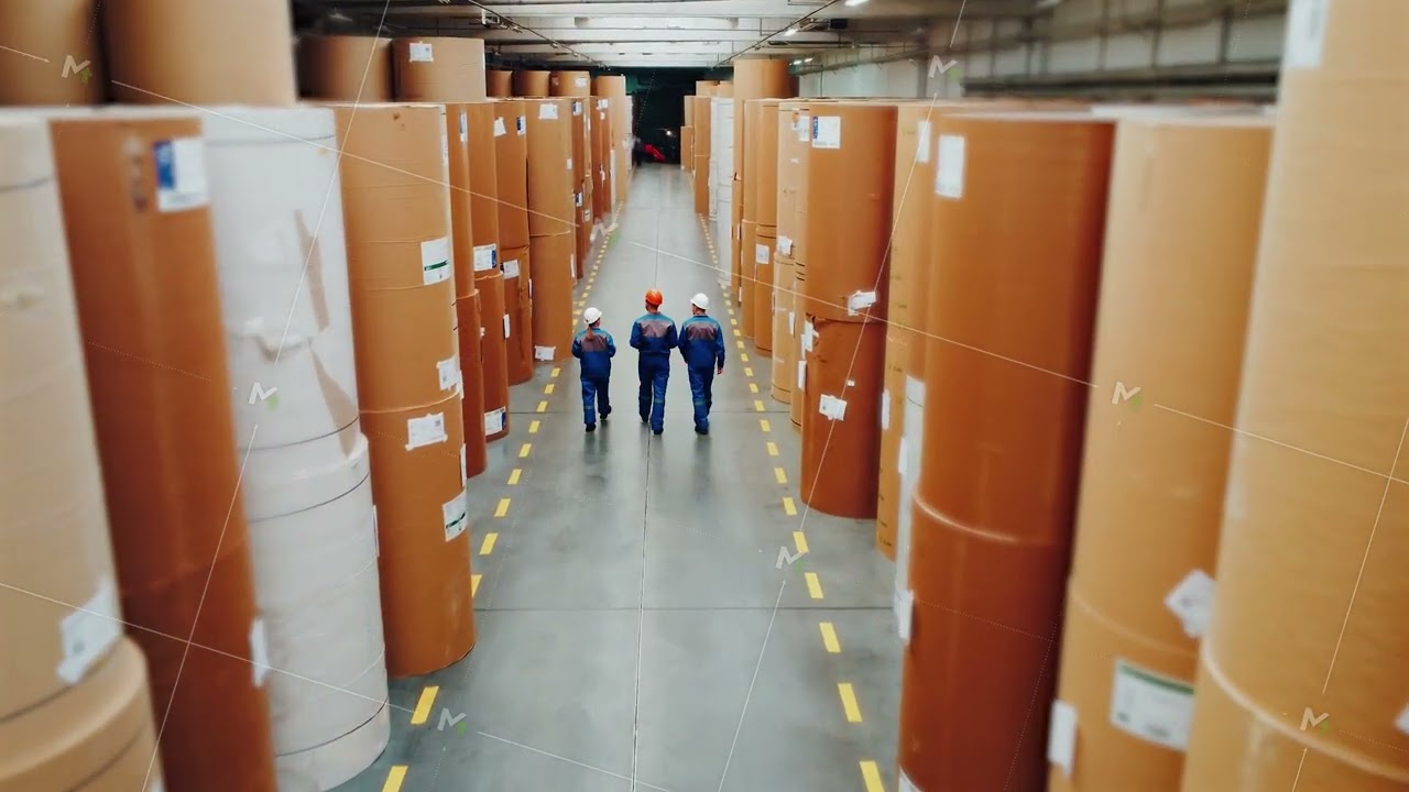 Engineers workers are taking inventory of warehouse. Paper industry, stock. Paper mill workers walk