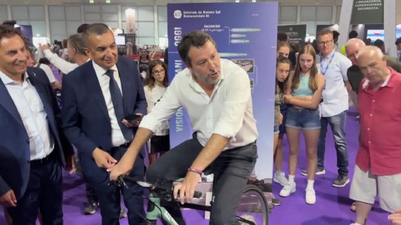 Salvini pedala una bicicletta che produce idrogeno al padiglione del Mit al Meeting di Rimini