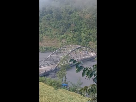 Bridge collapses after being knocked by floodwaters