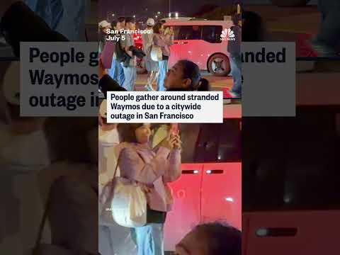 People gather around Waymos after power outage