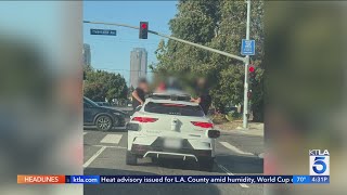 Teens riding outside Waymo vehicle in Santa Monica