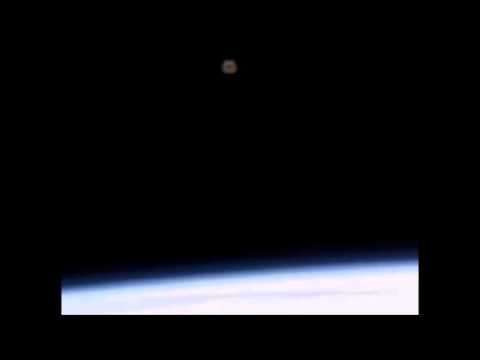 Green object above Earth.