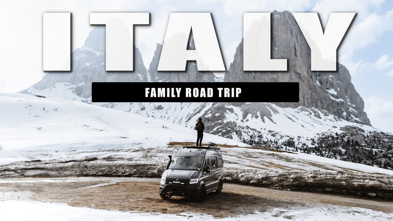 Man standing on top of a camper van in the Dolomites