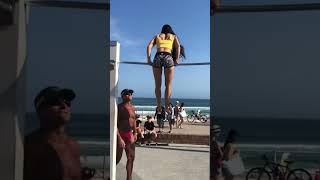Girl does muscle-ups at the beach