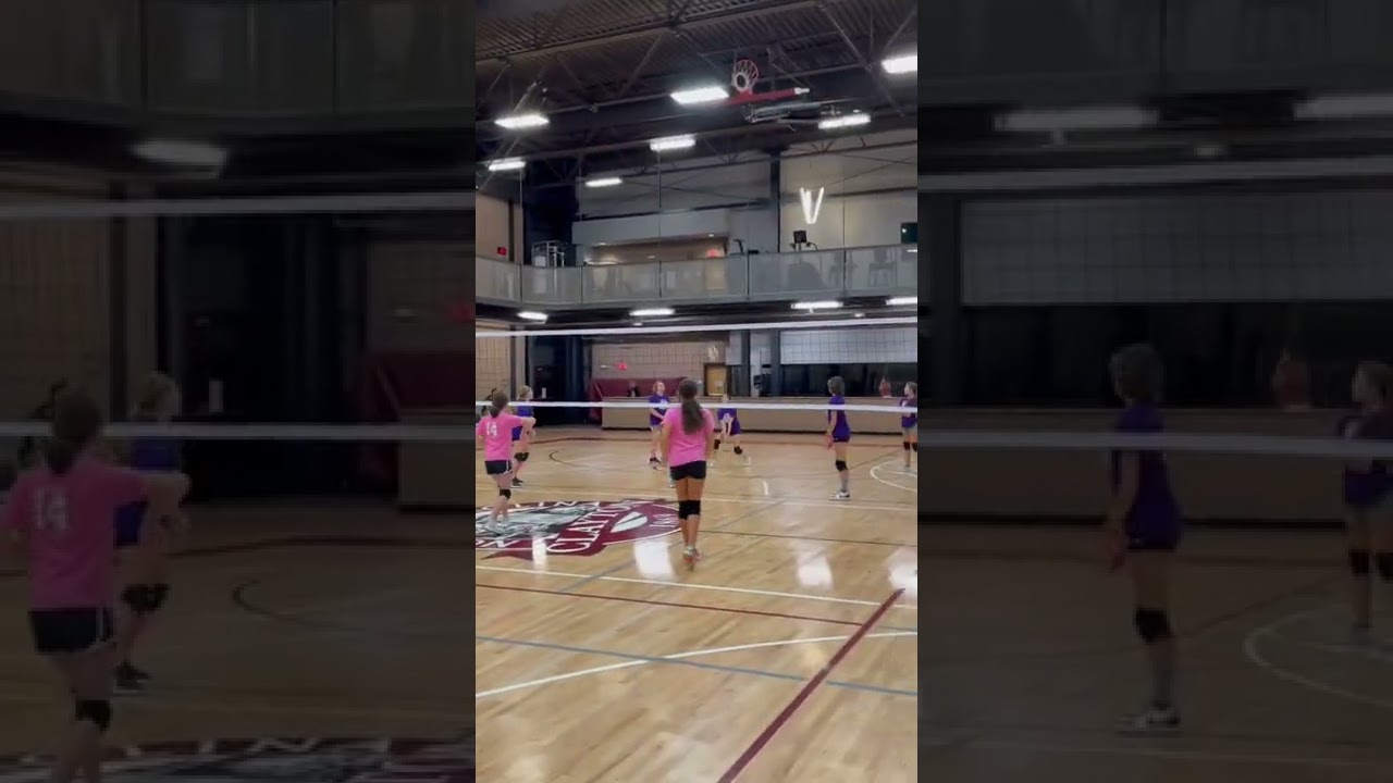 Hard Hit Girls Volleyball overhand serve over the net
