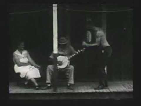 Roscoe Holcomb - 1962 interview + playing banjo to man dancing on porch and dogs playing by well