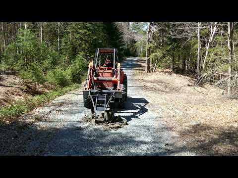 Kubota M5640 and FrostBite Grapple Pulling Out a Road Rock