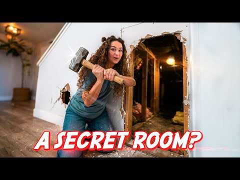 Woman with a sledgehammer breaks through a wall, revealing a wooden interior and debris on the floor; overlay reads 'A SECRET ROOM?'