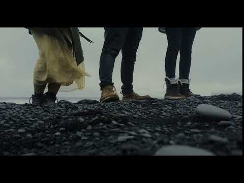 close up view of people foot standing on the black volcanic beach