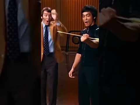 Bruce Lee catches the arrow with his hands.