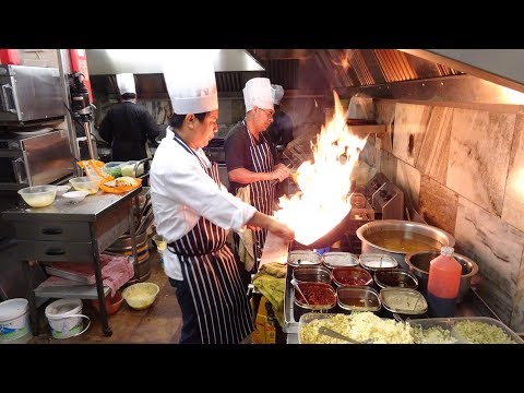 O calor da cozinha indo-chinesa do mestre wok em uma noite de sábado muito movimentada em um restaurante indiano