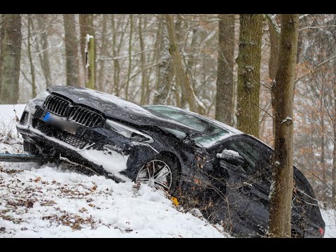 BWM-Fahrer kommt mit Sommerreifen von schneeglatter Straße ab