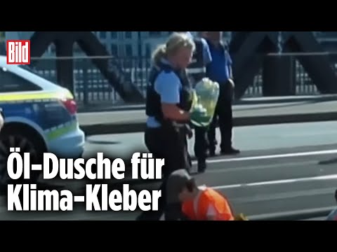 Polizistin (ver)schüttet Öl auf Klima-Kleber