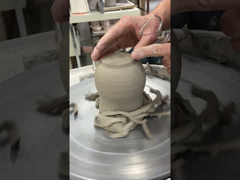 Trimming a raised foot on a mug.