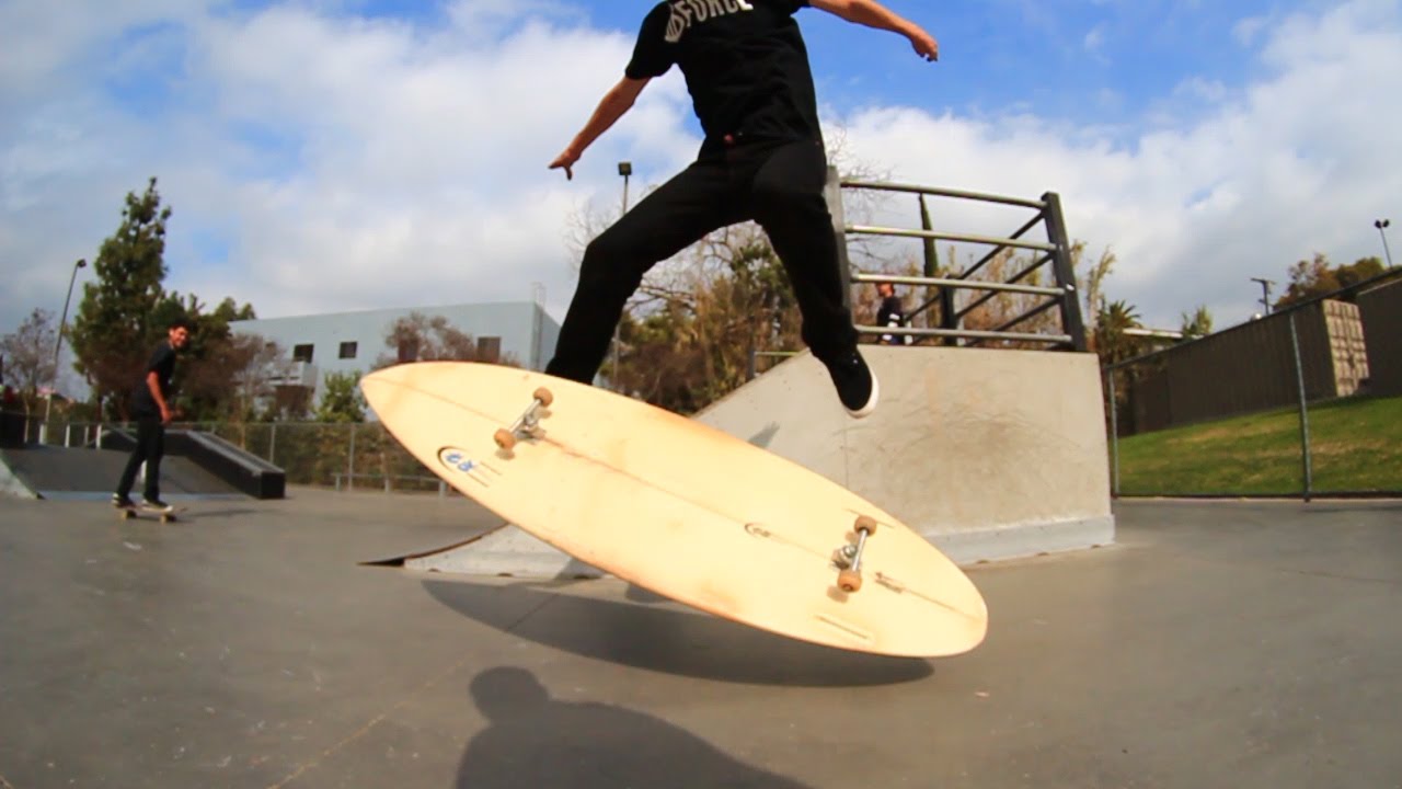Aaron Kyro plancha un Kickflip en una tabla de surf