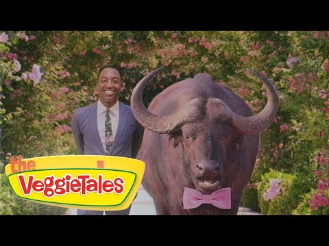 Smiling man in a blue suit stands beside a large buffalo wearing a pink bow tie, with a VeggieTales logo in the foreground and a floral backdrop.