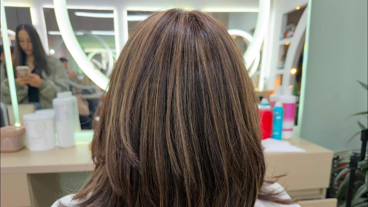 Resultado de un corte en capas con iluminaciones realizado en Narbo's Salón Spa Chía