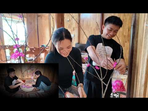 Duyen helped Tham decorate the flower tree, and Tham unexpectedly took Duyen's hand.