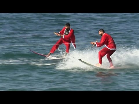 شاهد راكبو أمواج بزي بابا نويل في غزة
