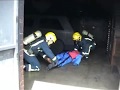Video clip of a fire drill drag dummy being carried out of a firehouse by two trainee fire recruits during Breathing Apparatus training at West Midlands Brigade Training Centre