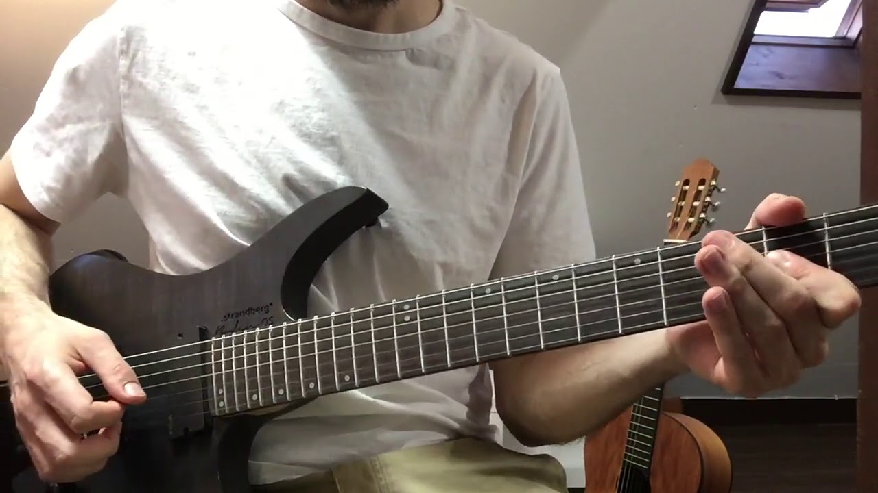 Guitarist demonstrating palm muting on the strings near the bridge for a chugging rhythm riff.