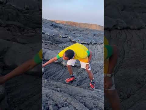 Man lights cigarette on molten lava from Erta Ale volcano in Afar, Ethiopia