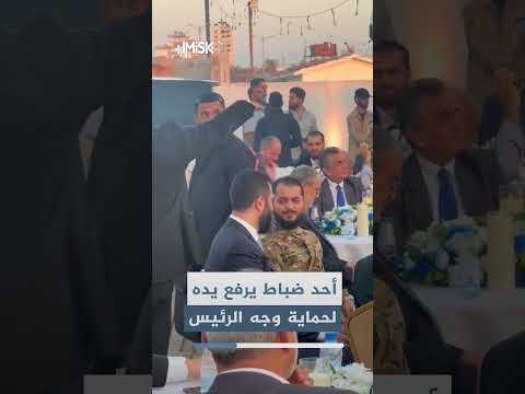 أحد ضباط وزارة الدفاع يرفع يده خوفاً على وجه الرئيس السوري أحمد الشرع أثناء زيارته لمحافظة طرطوس