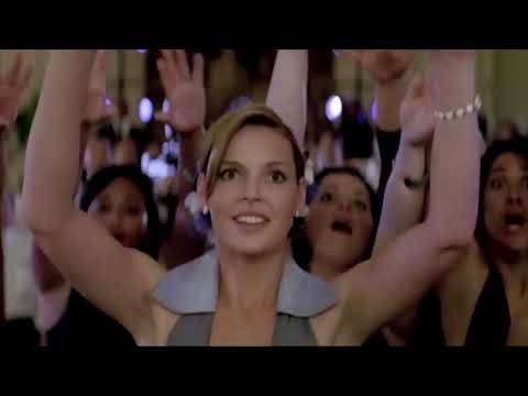 Trailer frame: crowded bar with neon signs, hinting at the film’s pivotal singalong