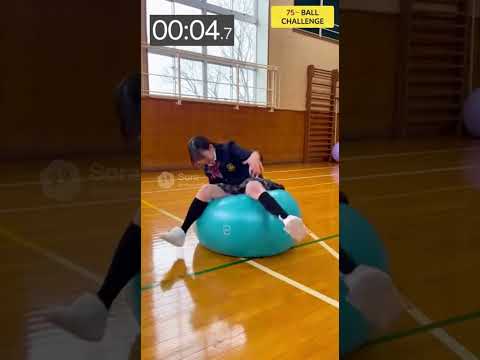女子高生が制服を着たまま、75センチのバランスボールに何分座れるか挑戦する。何回か失敗し、落ちる