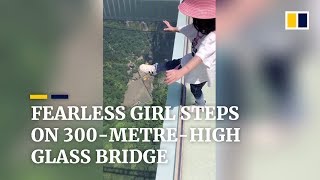 Fearless girl walks across 300-metre-high glass br