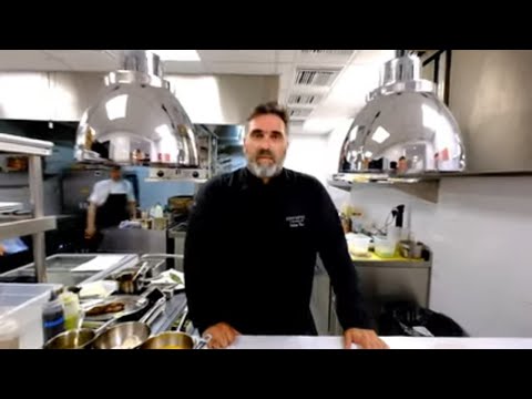 Chef Tasos Stefatos prepares Greek kleftiko lamb at Elements restaurant in Santorini, Greece