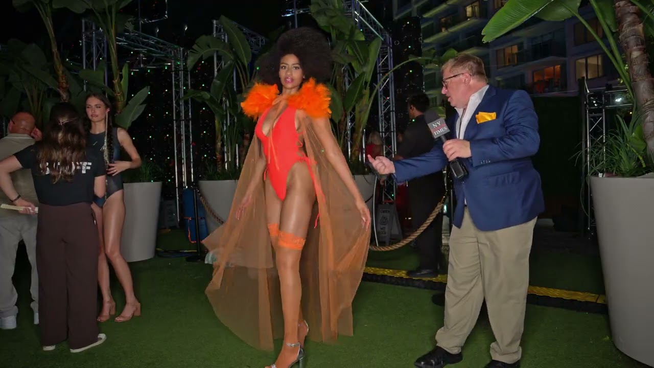 Model Infante at Miami Swim Week The Shows wearing orange piece with sheer cape