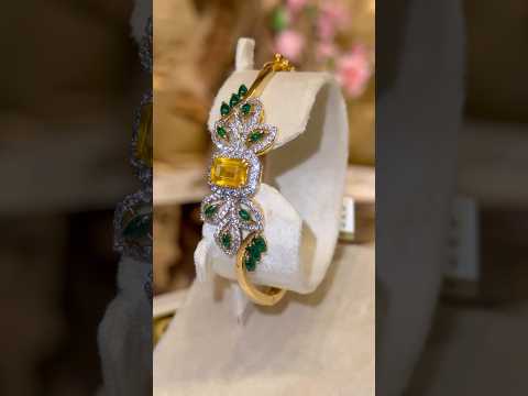 A dazzling yellow 💎embraced by shimmering zircons✨& graceful green leaf motifs🌸all set in 21k gold