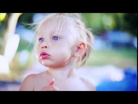 close up of a hungry little girl with blond hair eating grapes in summer park concept of