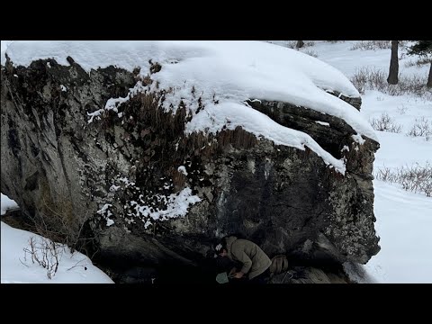 Surviving the night under a Rock in the snow. No sleeping bag