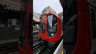 Cross crossing London underground of district line train at Upton Park Station |