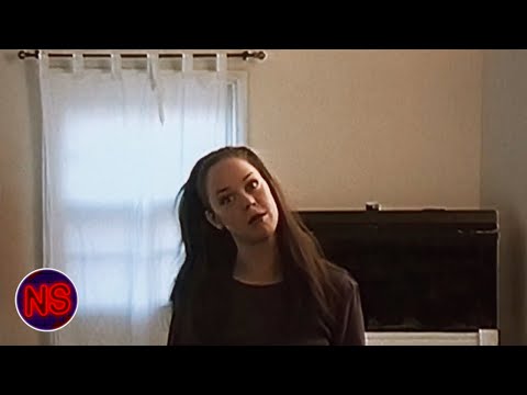 Trailer frame: map unfolded under flashlight, grainy Hi8 texture