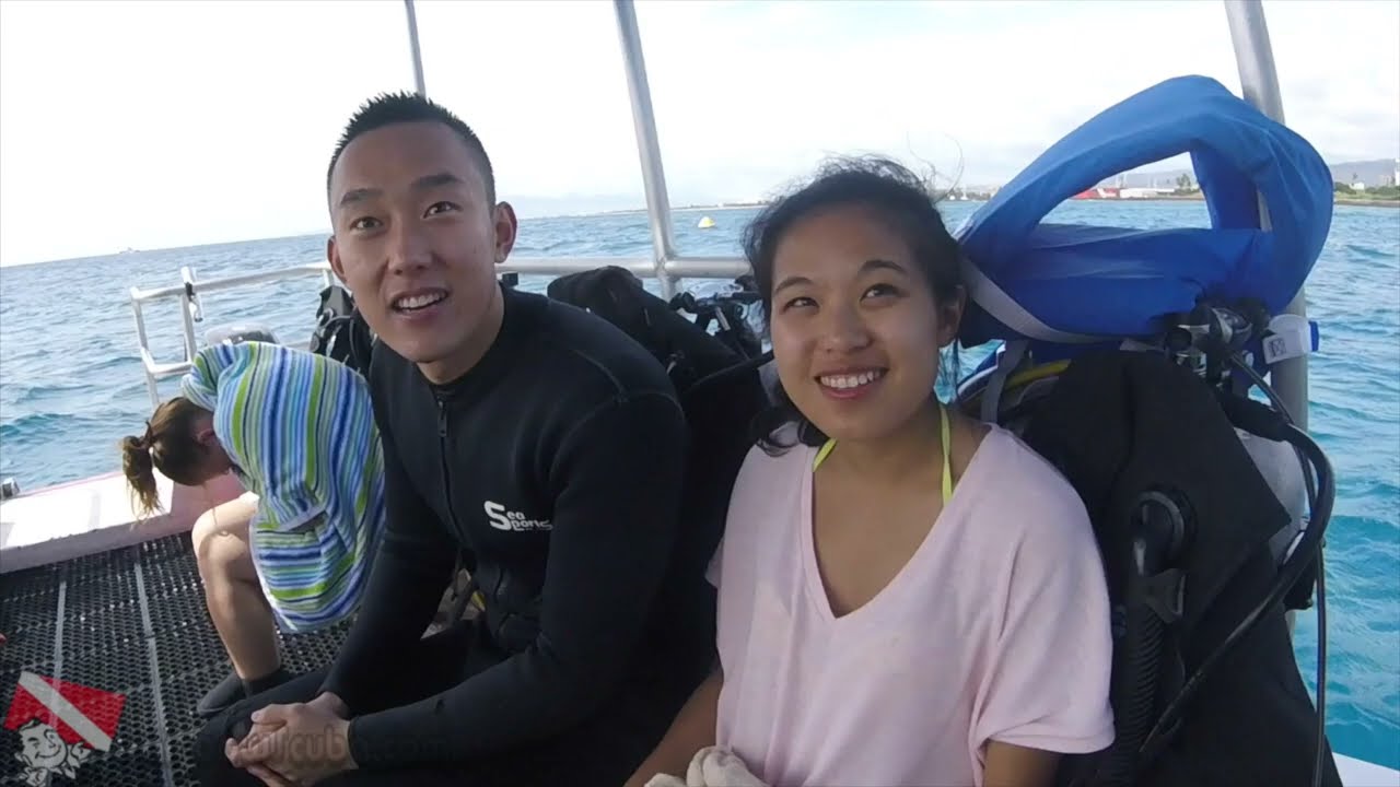 A group of first-time SCUBA divers descending along a line at the Kewalo Pipe dive site in Honolulu, Hawaii.