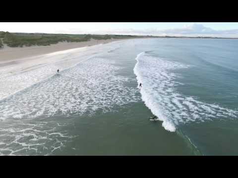Drone view of surfers and small swell at Beadnell Bay