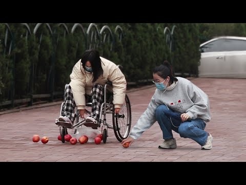 看到坐輪椅的女孩手裡的水果撒了一地，路人：你別動，我幫你